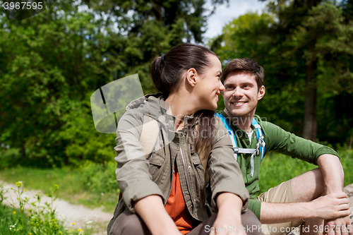 Image of smiling couple with backpacks in nature