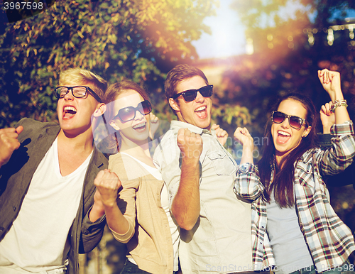 Image of group of happy friends showing triumph gesture