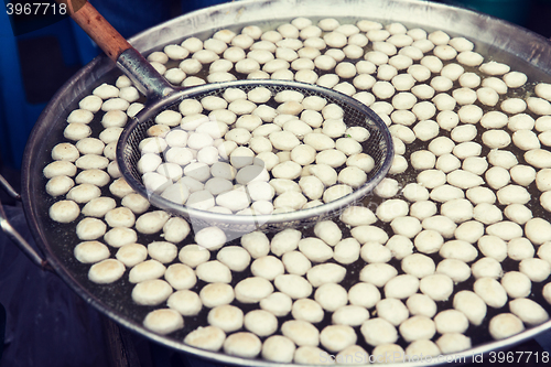 Image of meat or rice balls frying in oil at street market