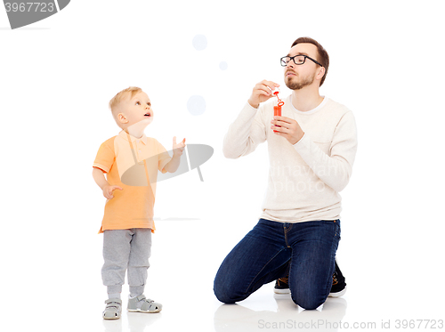 Image of father with son blowing bubbles and having fun