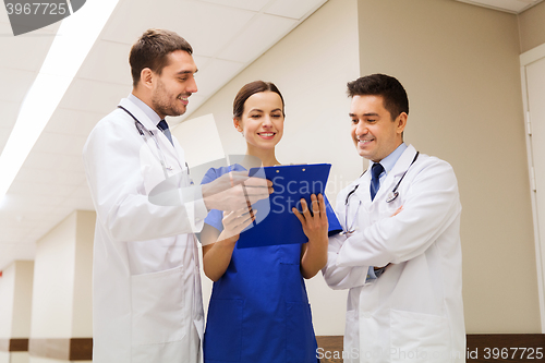 Image of group of happy medics with clipboard at hospital