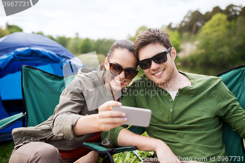 Image of couple of travelers taking selfie by smartphone