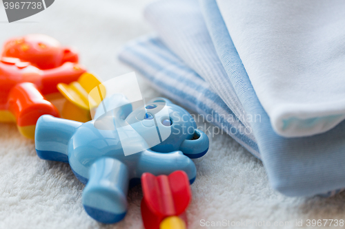 Image of close up of baby rattle and clothes for newborn