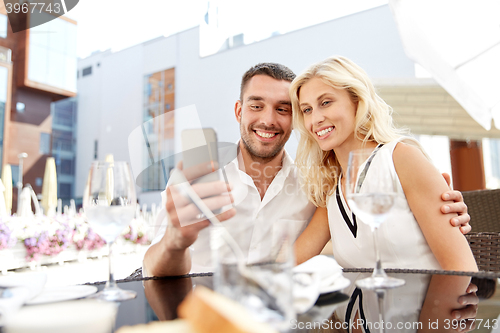 Image of couple taking selfie with smatphone at restaurant