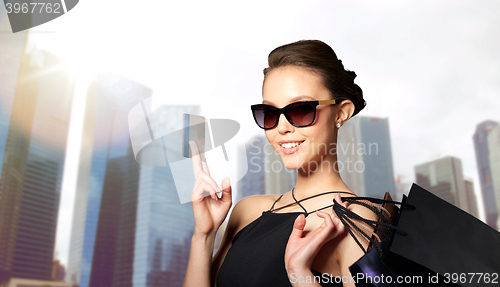 Image of happy woman with credit card and shopping bags