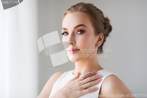 Image of smiling woman in white dress with diamond jewelry