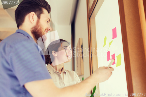 Image of creative team with stickers on glass at office