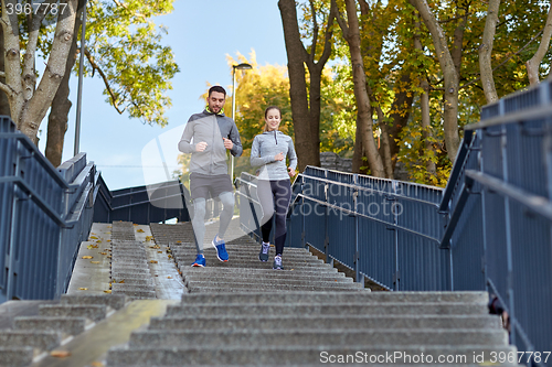 Image of happy couple running downstairs in city