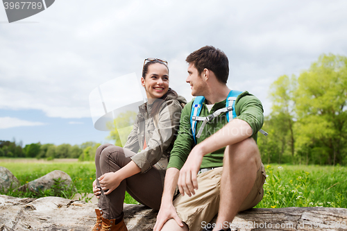 Image of smiling couple with backpacks in nature