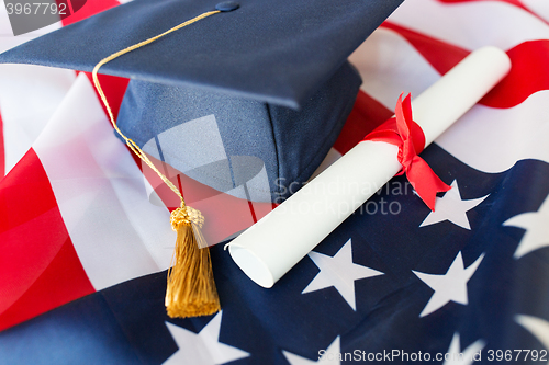 Image of bachelor hat and diploma on american flag