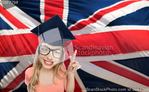 Image of student woman in mortarboard over english flag