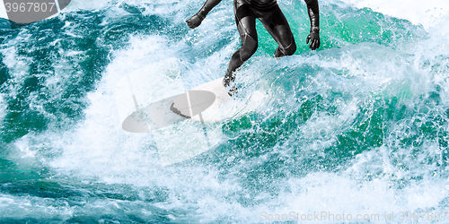 Image of Surfer rides on turquoise ocean wave