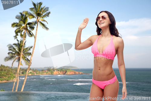 Image of happy woman in sunglasses and bikini on beach