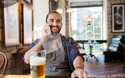 Image of man with smartphone and beer calling at bar or pub