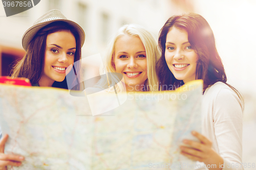 Image of beautiful girls looking into tourist map in city