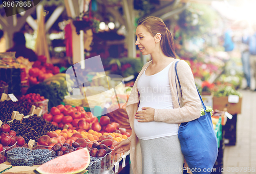 Image of pregnant woman choosing food at street market