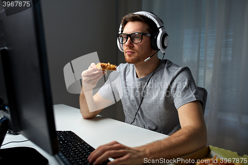 Image of man in headset playing computer video game at home