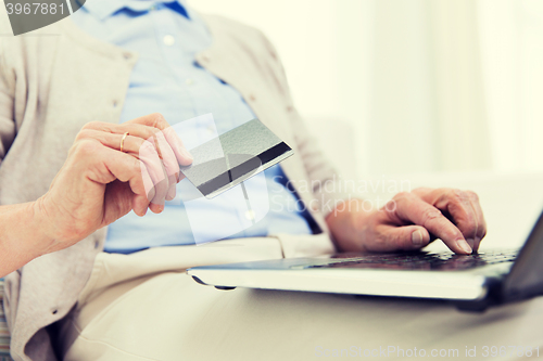 Image of senior woman with laptop and credit card at home