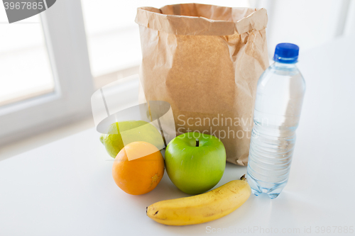 Image of basket of fresh ripe fruits and water at kitchen