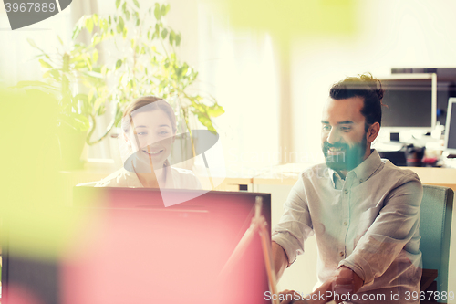 Image of happy creative team with computer in office