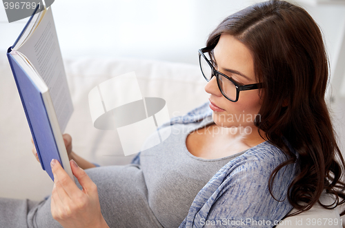 Image of pregnant woman reading book at home