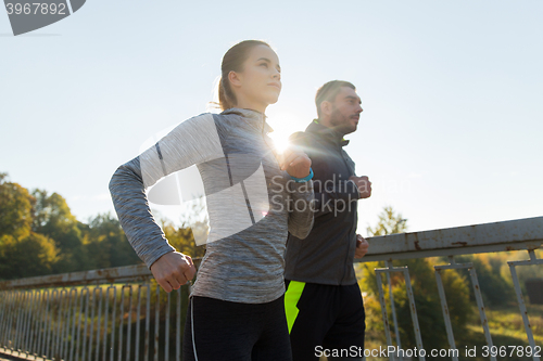 Image of happy couple running outdoors