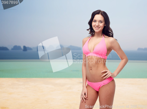 Image of happy woman in pink bikini swimsuit on beach