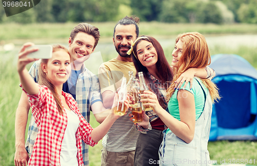 Image of happy friends taking selfie by smartphone at camp