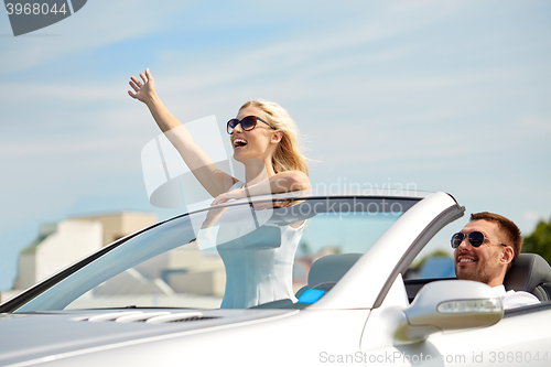 Image of happy man and woman driving in cabriolet car