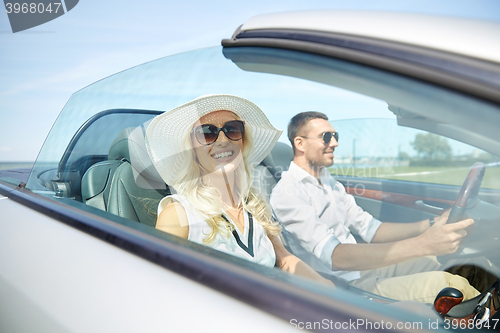 Image of happy man and woman driving in cabriolet car