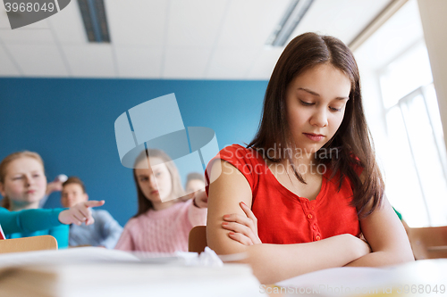 Image of students gossiping behind classmate back at school