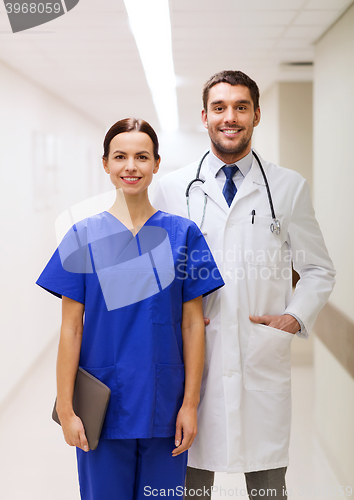 Image of smiling doctor in white coat and nurse at hospital