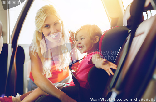 Image of happy mother fastening child with car seat belt