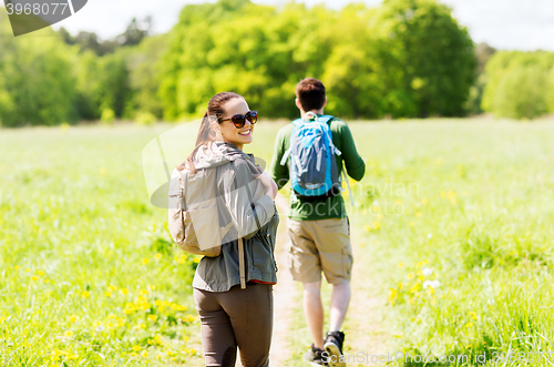 Image of happy couple with backpacks hiking outdoors