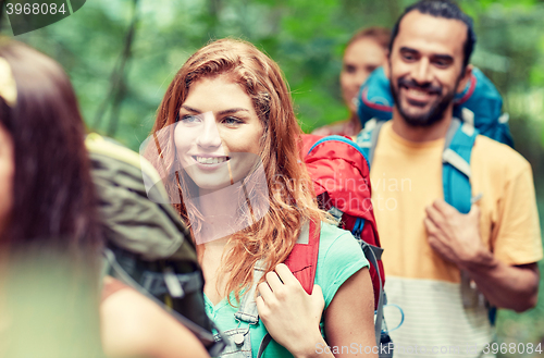 Image of group of smiling friends with backpacks hiking