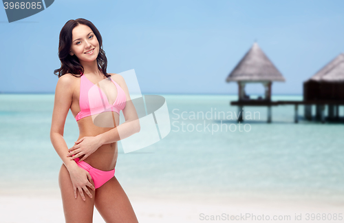 Image of happy young woman in pink bikini swimsuit