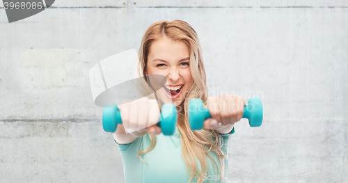 Image of smiling beautiful young sporty woman with dumbbell