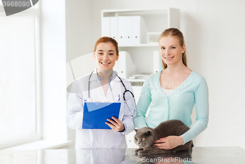 Image of happy woman with cat and doctor at vet clinic