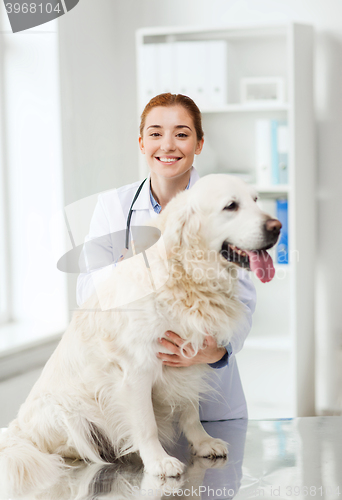 Image of happy doctor with retriever dog at vet clinic