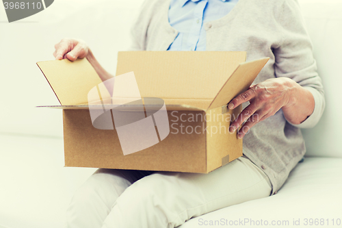 Image of close up of senior woman with parcel box at home