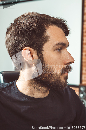 Image of The profile of young man looking at camera