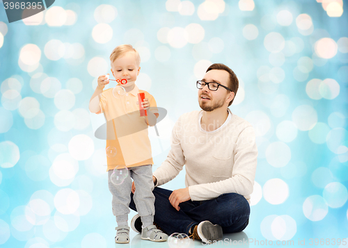 Image of father with son blowing bubbles and having fun