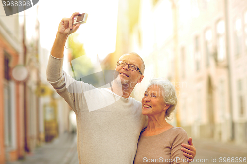 Image of senior couple photographing on city street