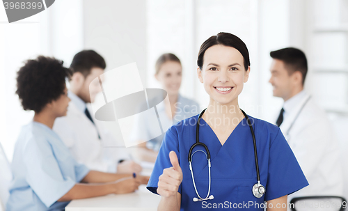 Image of happy doctor over group of medics at hospital