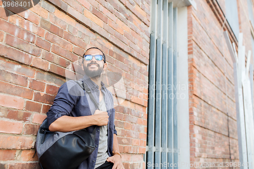 Image of happy man with backpack standing at city street