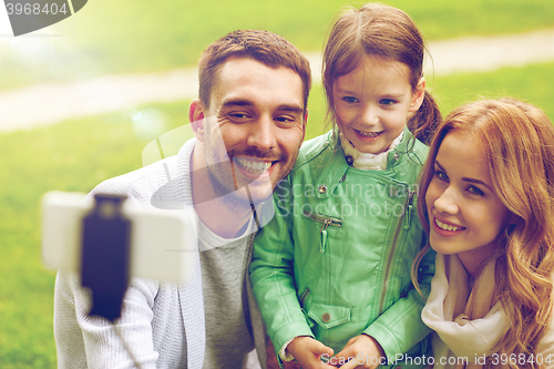 Image of happy family taking selfie by smartphone outdoors