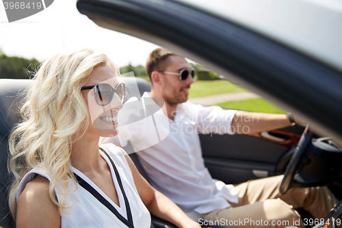 Image of happy man and woman driving in cabriolet car