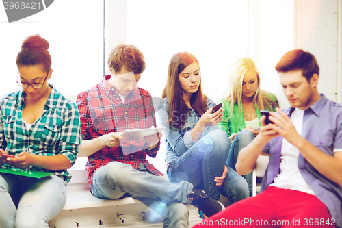 Image of students looking into devices at school