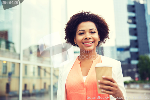 Image of happy african businesswoman with coffee in city