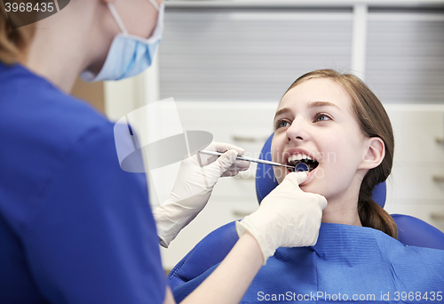 Image of female dentist checking patient girl teeth